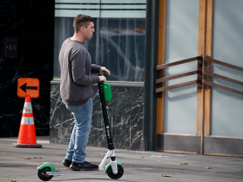 OAKLAND, CA: JANUARY 07: A man rides a Lime scooter on the sidewalk near Broadway in Oakland, Calif....