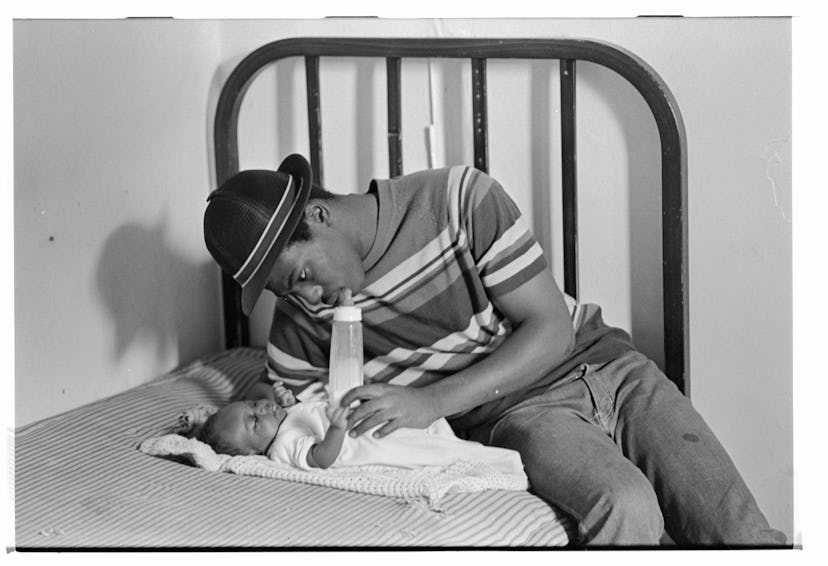 Father Sitting on Bed with Infant   (Photo by David Turnley/Corbis/VCG via Getty Images)