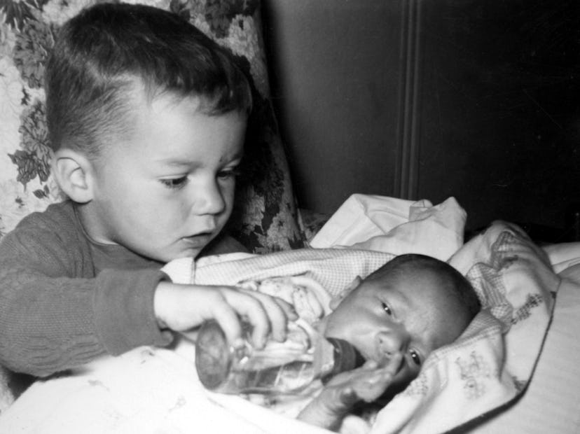 Boy feeding baby a bottle, August 1961. (Photo by Mark Jay Goebel/Getty Images)