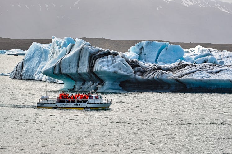 A small ship driving next to the icebergs at Jökulsárlón
