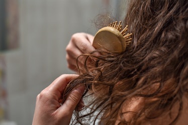 Young Upset Woman In Bathroom Holding Brush With Hair , Hair Loss And Hair Care Concept
