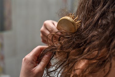 Young Upset Woman In Bathroom Holding Brush With Hair , Hair Loss And Hair Care Concept