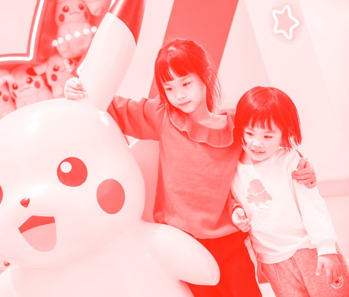 FUZHOU, CHINA - APRIL 11: Children pose for a photo with a Pikachu toy during a Pokemon-themed activ...