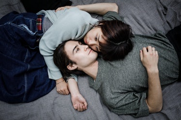 Young Couple Lying down on a bed, holding each other