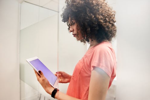 Woman looks at phone to increase interaction on Instagram Stories. 