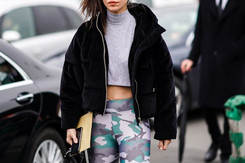 PARIS, FRANCE - FEBRUARY 28: A guest wears sunglasses, a black coat with fluffy parts, a gray wool t...
