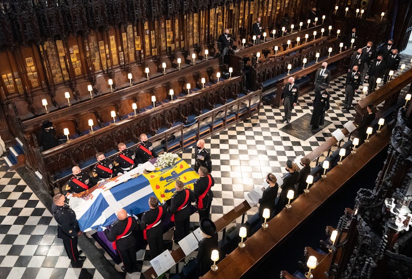 Queen Elizabeth II (L) watches as pallbearers carry the coffin of Britain's Prince Philip, Duke of E...