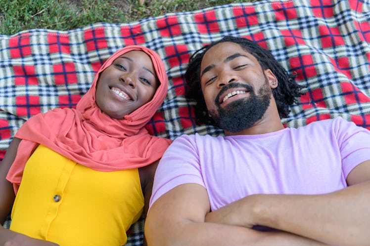A Man and his Lovely Wife of Muslim Ethnicity are Laying on Blanket in Park and Spending a Wonderful...