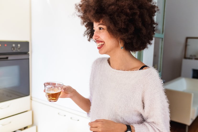 A smiling woman drinks beer. Post-COVID vaccine you should alcohol for up to 72 hours. 