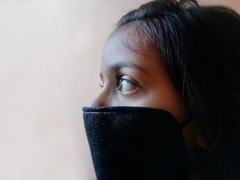 A woman wears a full COVID mask. A mask covering both nose and mouth is recommended for COVID protec...