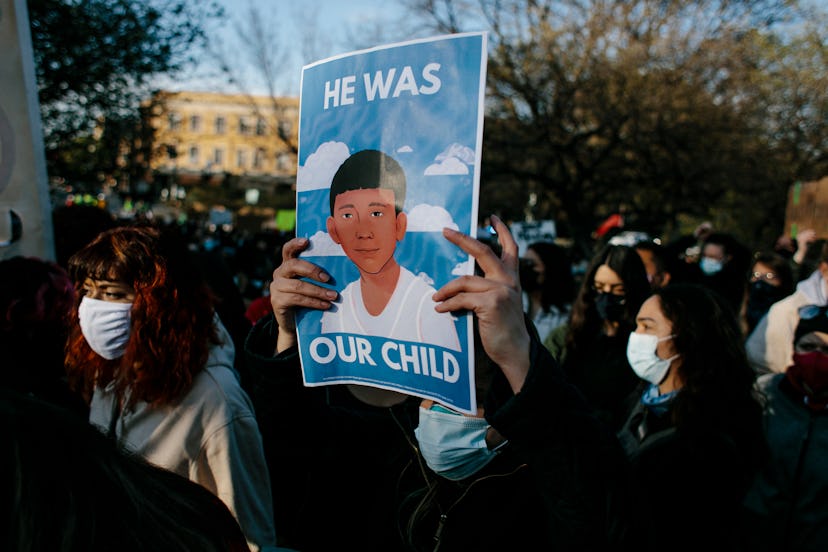 "He was our child." A protester holds a sign at a press conference at the Logan Square Monument in C...