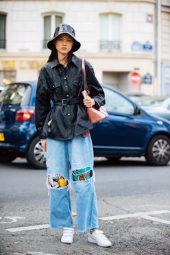 PARIS, FRANCE - SEPTEMBER 29:  Model Guannan Cai weasr a black rain/bucket hat, black leather jacket...