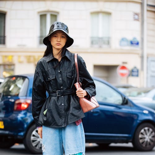 PARIS, FRANCE - SEPTEMBER 29:  Model Guannan Cai weasr a black rain/bucket hat, black leather jacket...