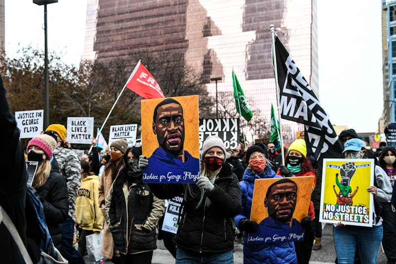 People hold placards as they protest outside of the Courthouse during the trial of former Minneapoli...