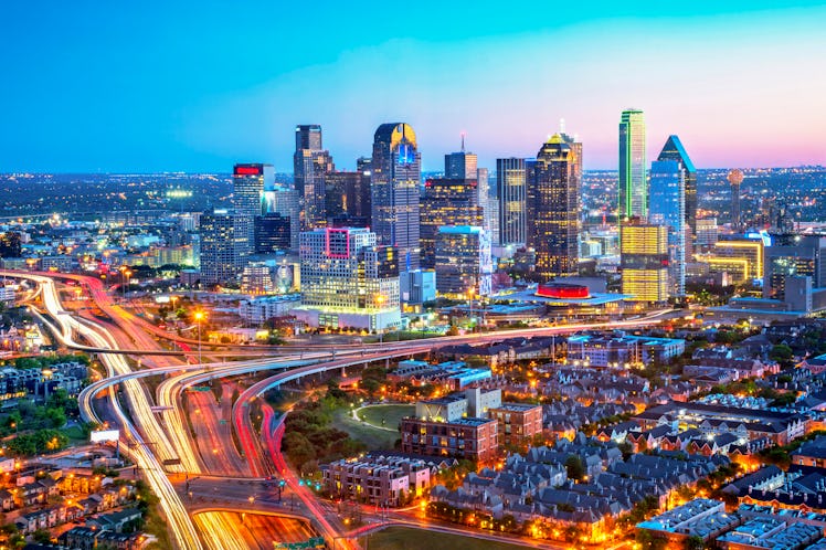 The Dallas skyline is a colorful landscape at dusk. Interstates 45 and 35 converge in a design fille...