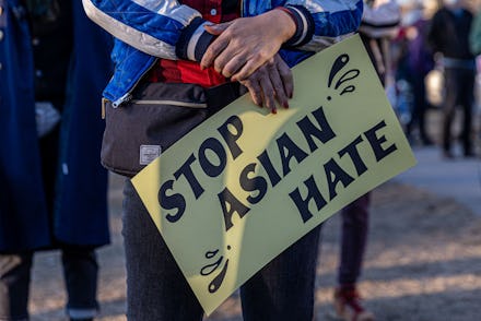 A person holds a sign during the "Asian Solidarity March" rally against anti-Asian hate in response ...