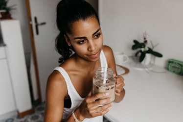 A young woman holds a cold brew she made at home after finding a recipe on TikTok.
