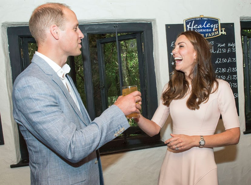 Britain's Catherine, Duchess of Cambridge (R) laughs as she offers Britain's Prince William, Duke of...