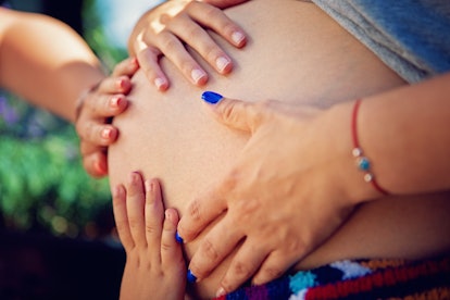 Hands on woman's pregnant belly