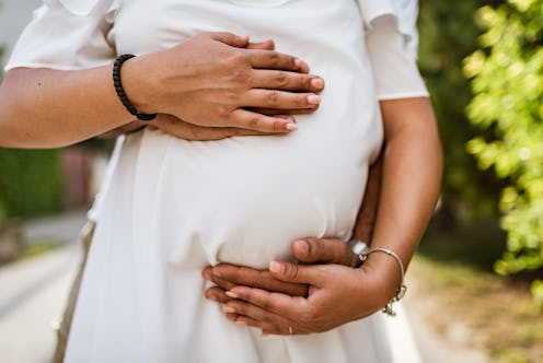 Future parents at sunset. They are holding woman’s pregnant belly!