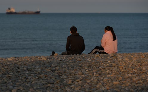 A couple watch a boat in the sea near Bray's rocky beach at sunset, during the COVID-19 lockdown. 
O...