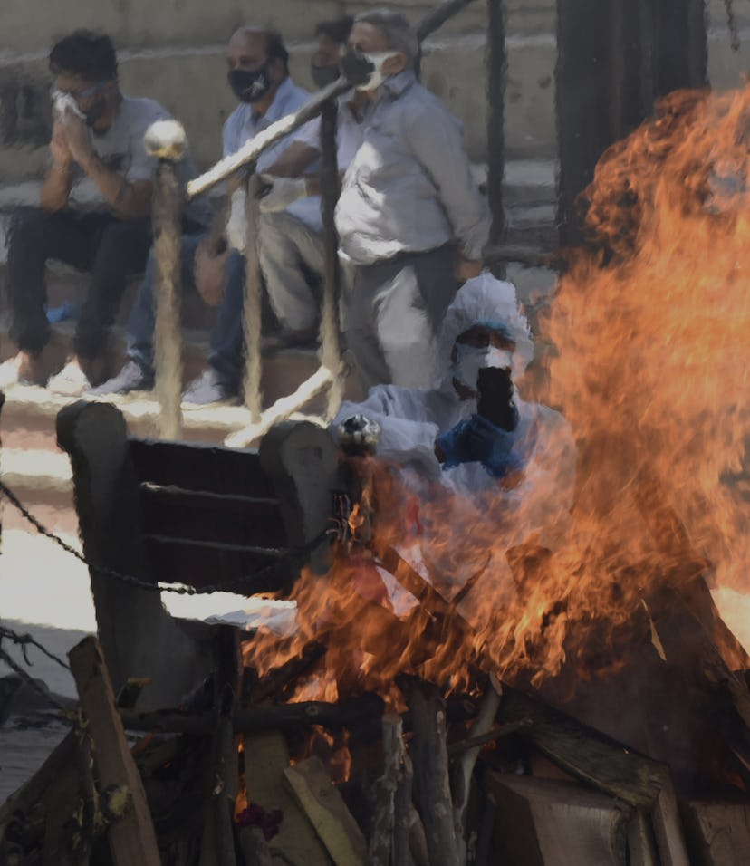 NEW DELHI, INDIA - APRIL 25: Relatives of a Covid-19 victim perform the last rites during cremation ...
