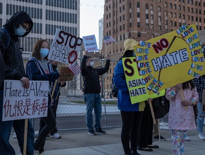 People hold up signs during a Stop Asian Hate rally in downtown Detroit, Michigan on March 27,2021, ...