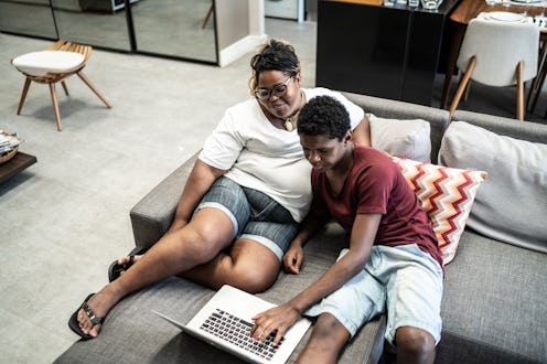 Mother and son using laptop together at home