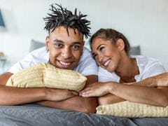 African American couple laying in bed in the morning