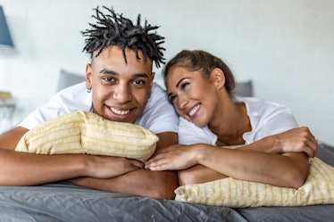 African American couple laying in bed in the morning