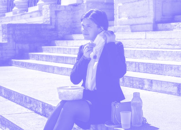 Woman taking off her mask to take her lunch break in the street