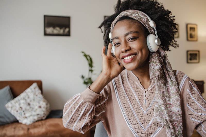 An African woman is at home, listening to music and relaxing