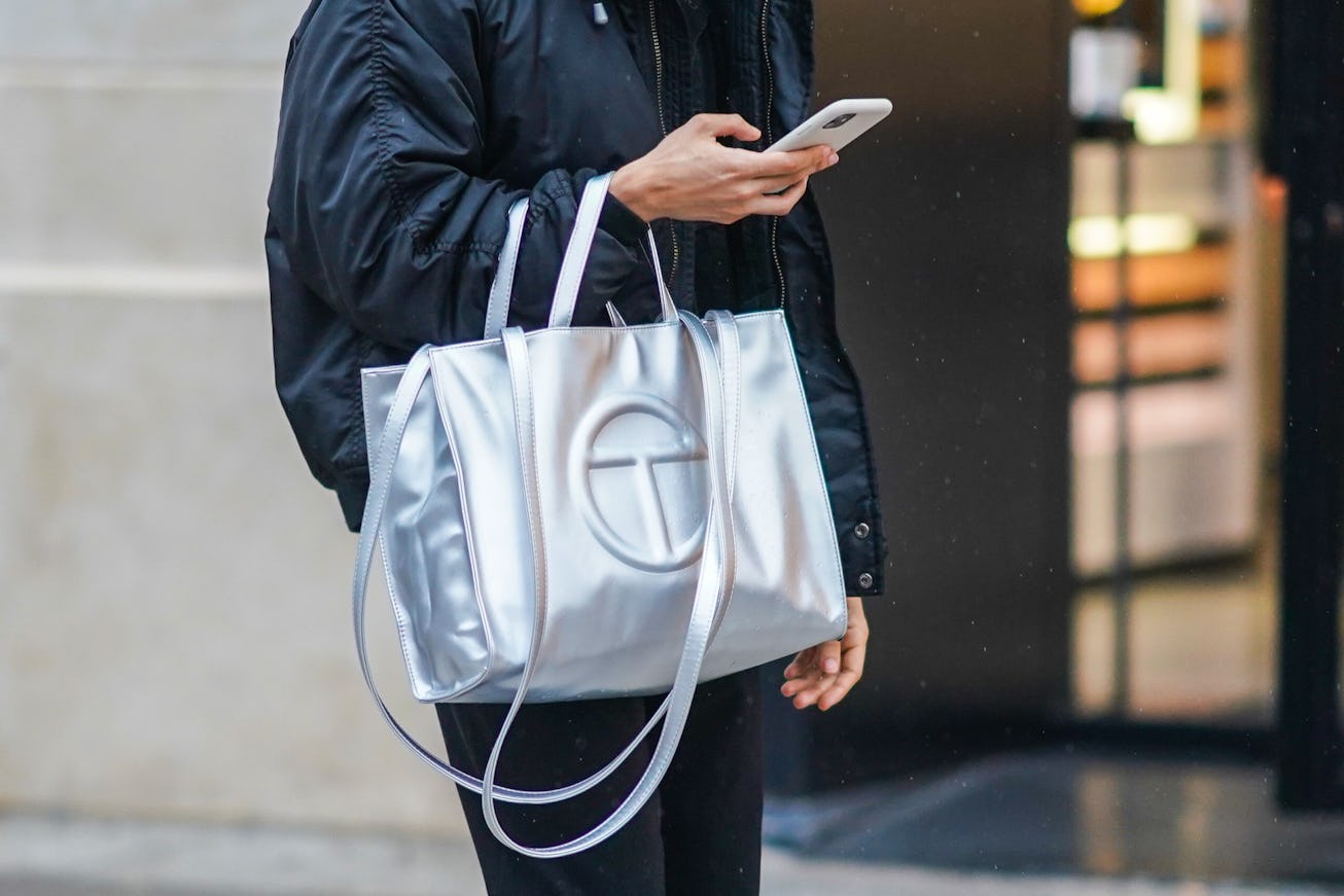 PARIS, FRANCE - DECEMBER 12: A passerby wears a black bomber jacket and a silver Telfar logo large b...