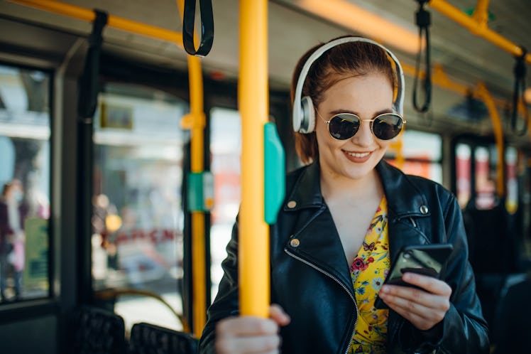 Woman Listening Music On Phone and texting while Riding In Bus