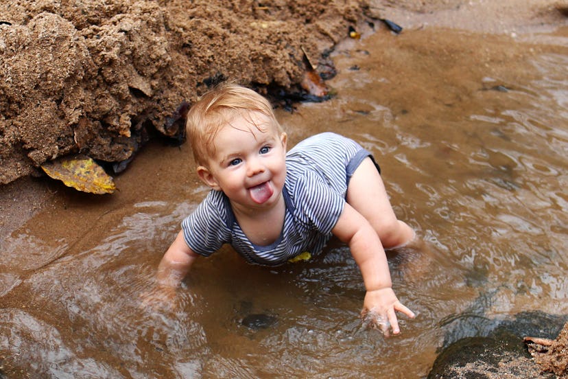 Baby playing in a stream in a story about Capricorn girl names.