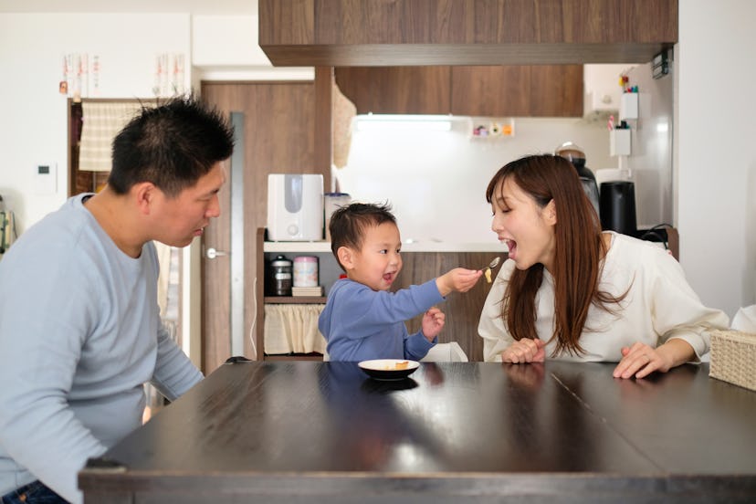 Child feeding sweet food to parents at home