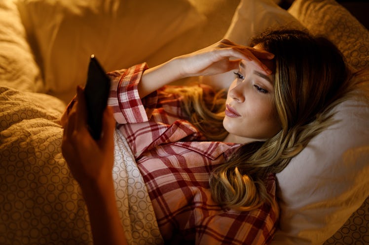 Sad young woman reading bad news on smartphone