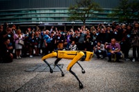 People take pictures and videos of Boston Dynamics Robot Dog named "Spot" during a presentation on t...