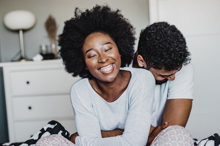 Young African American couple hugging in bed in the morning