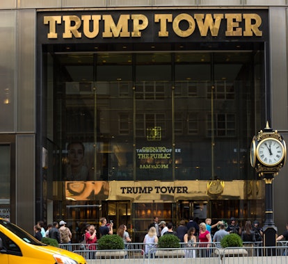 New York, NY: Trump Tower, with a passing yellow taxicab on Fifth Ave, and a small crowd on the side...