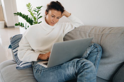 A woman in a white sweater tries to use INstagram without an account.