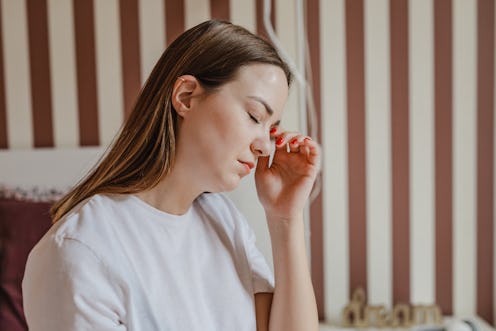 A sad young woman in bed is having a headache