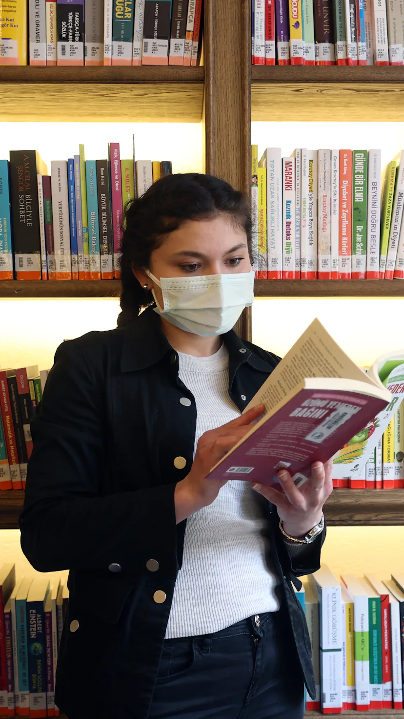 ISTANBUL, TURKEY - APRIL 01: A woman inspects books at Nevmekan Selimiye Library serving within the ...