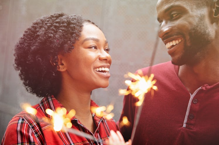 Couple celebrating with sparklers and sharing warm smiles