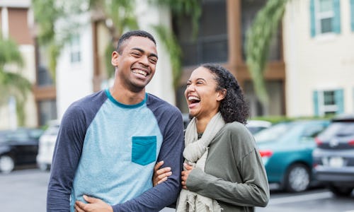 A couple laughs on the street. Gemini and leo compatibility. Leo and gemini compatibility.