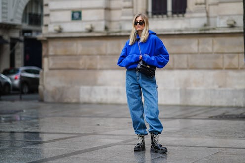 PARIS, FRANCE - MARCH 11: Xenia Adonts wears sunglasses from Linda Farrow, a bold blue hoodie sweate...