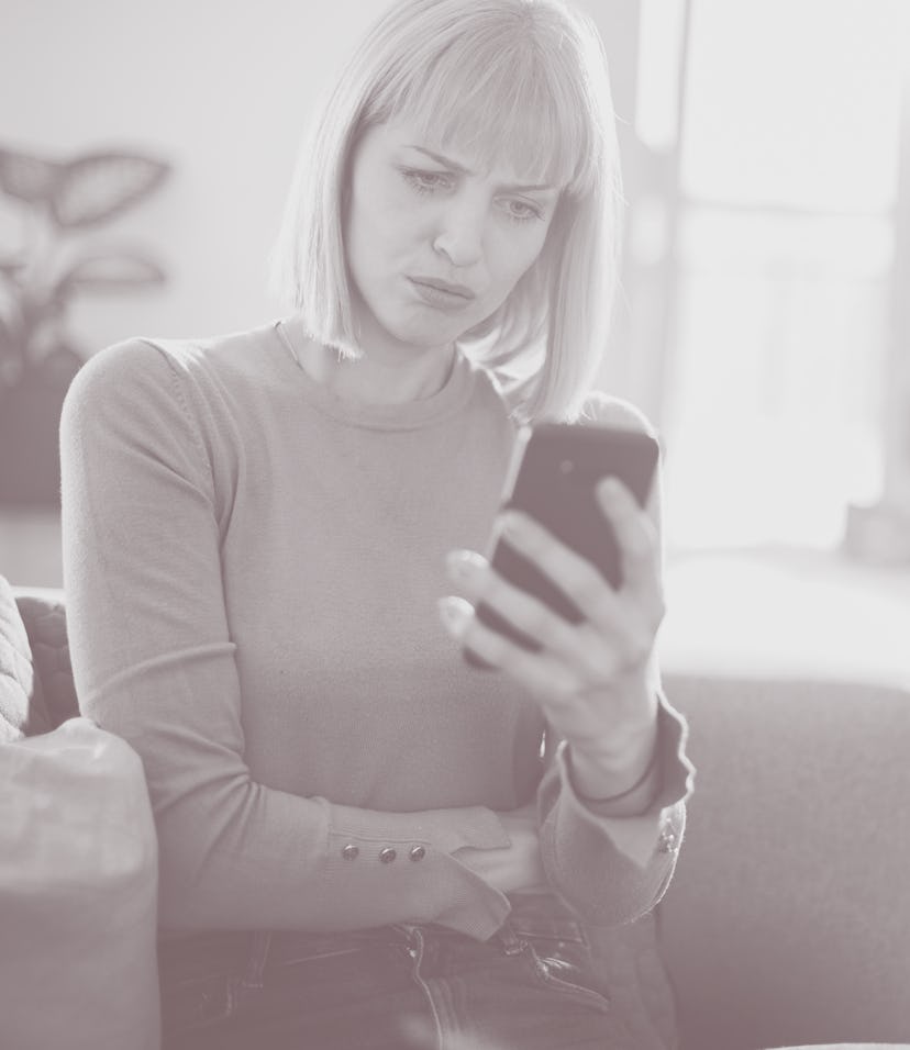 A businesswoman is reading an e-mail from a coworker. She's feeling surprised in a negative way.