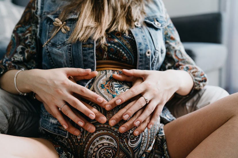 woman and man with hands on pregnant belly