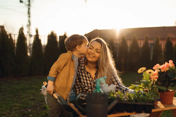 Young woman planting flower with her sons