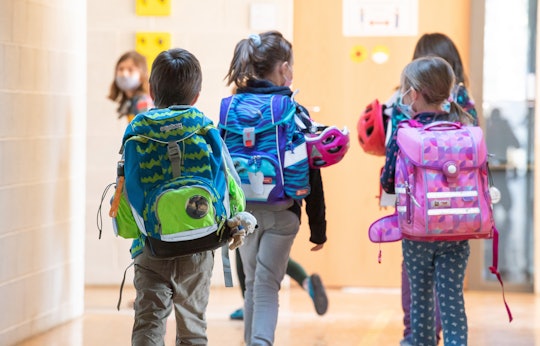 22 February 2021, Bavaria, Munich: Children walk down a hallway of their school with their satchels....